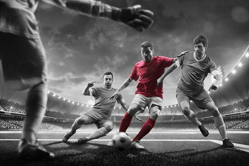 Striker in red getting past two defenders